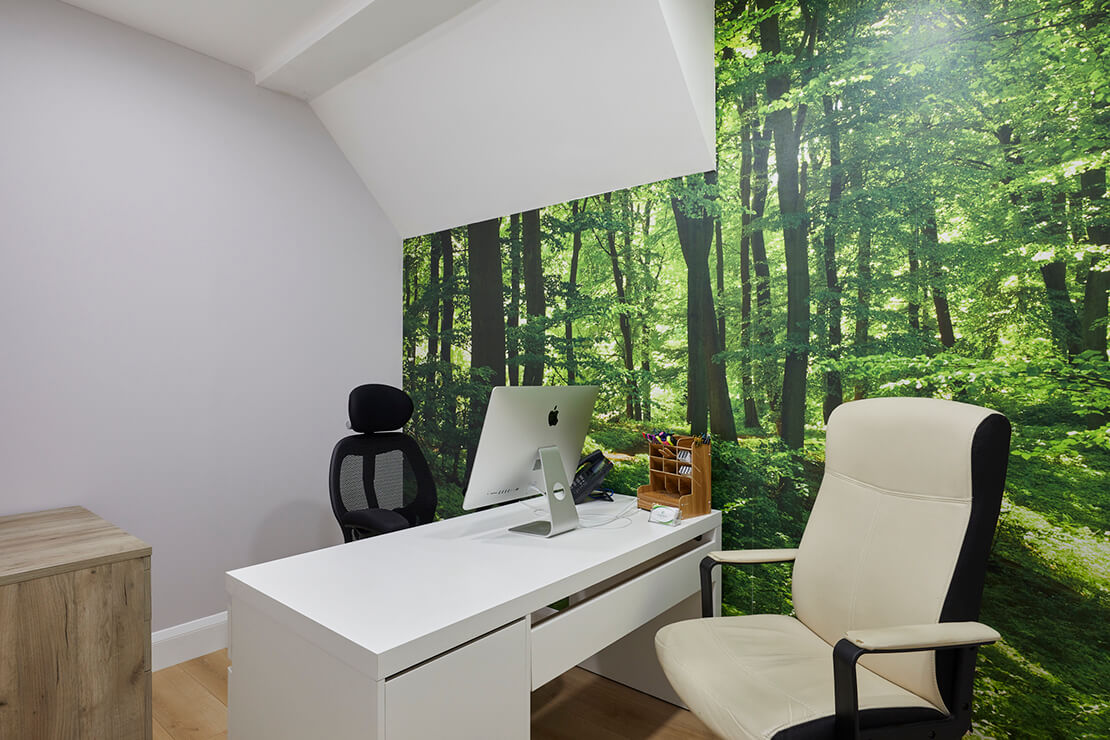 office with white walls, simple white desk and forest wallpaper
