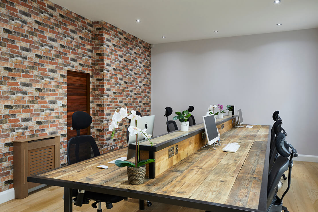 office with red brick interor wall and modern workstation