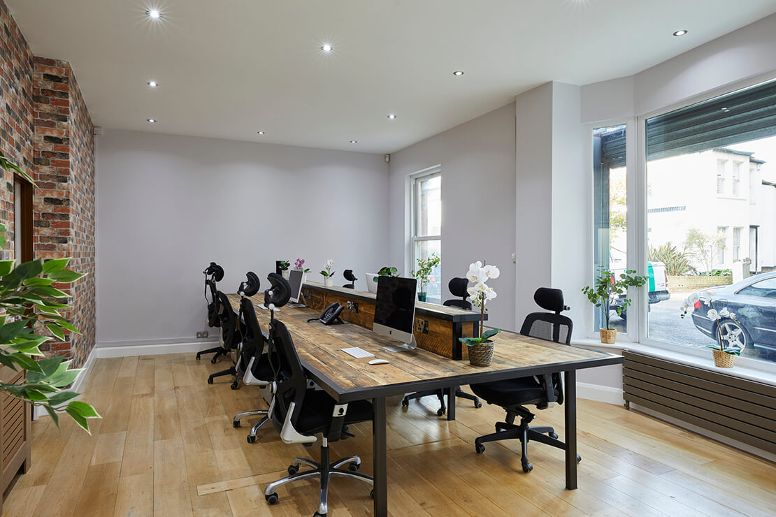modern office with wooden flooring and workstation in centre