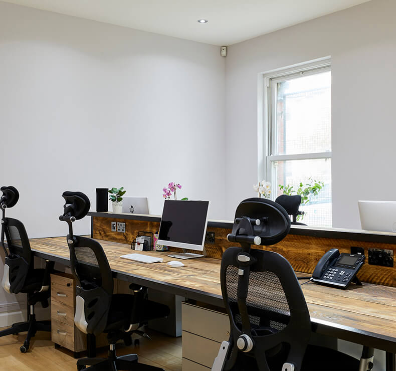 wooden workstation with white walls and medium windows